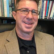 picture of man sitting on front of books